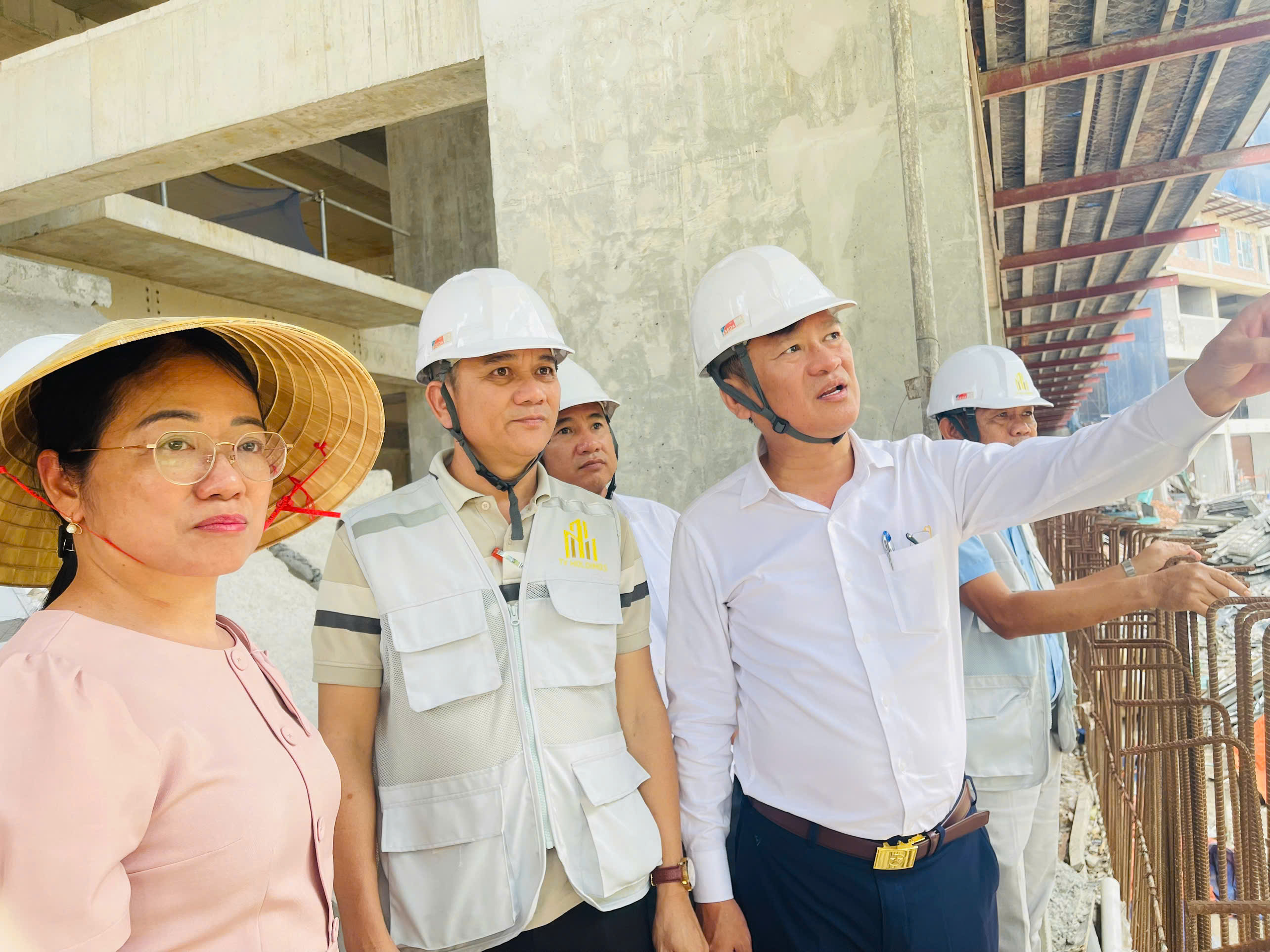 Đồng chí Nguyễn Minh Bình trao đổi với đại diện đơn vị thi công, kiểm tra thực tế các hạng mục tại công trình.