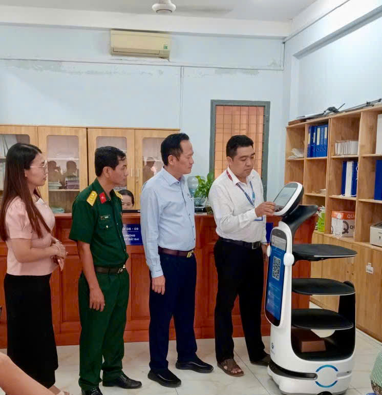 Bí thư Đảng ủy phường Biên Hòa - Ông Nguyễn Minh Bình cùng cán bộ, công chức trực tiếp kiểm tra, trải nghiệm các chức năng của Robot AI tại Trung tâm Phục vụ hành chính công phường.