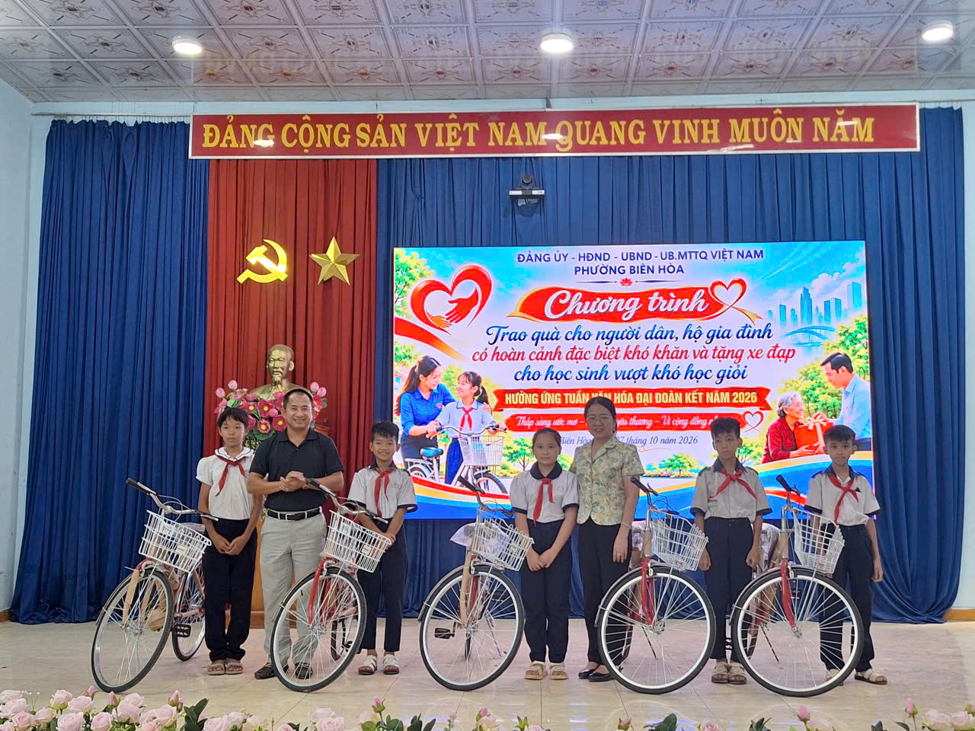 Đồng chí Trần Thế Anh, Phó Bí thư Thường trực Đảng ủy và đồng chí Phạm Thị Mỹ Phương trao tặng xe đạp cho học sinh vượt khó học giỏi.